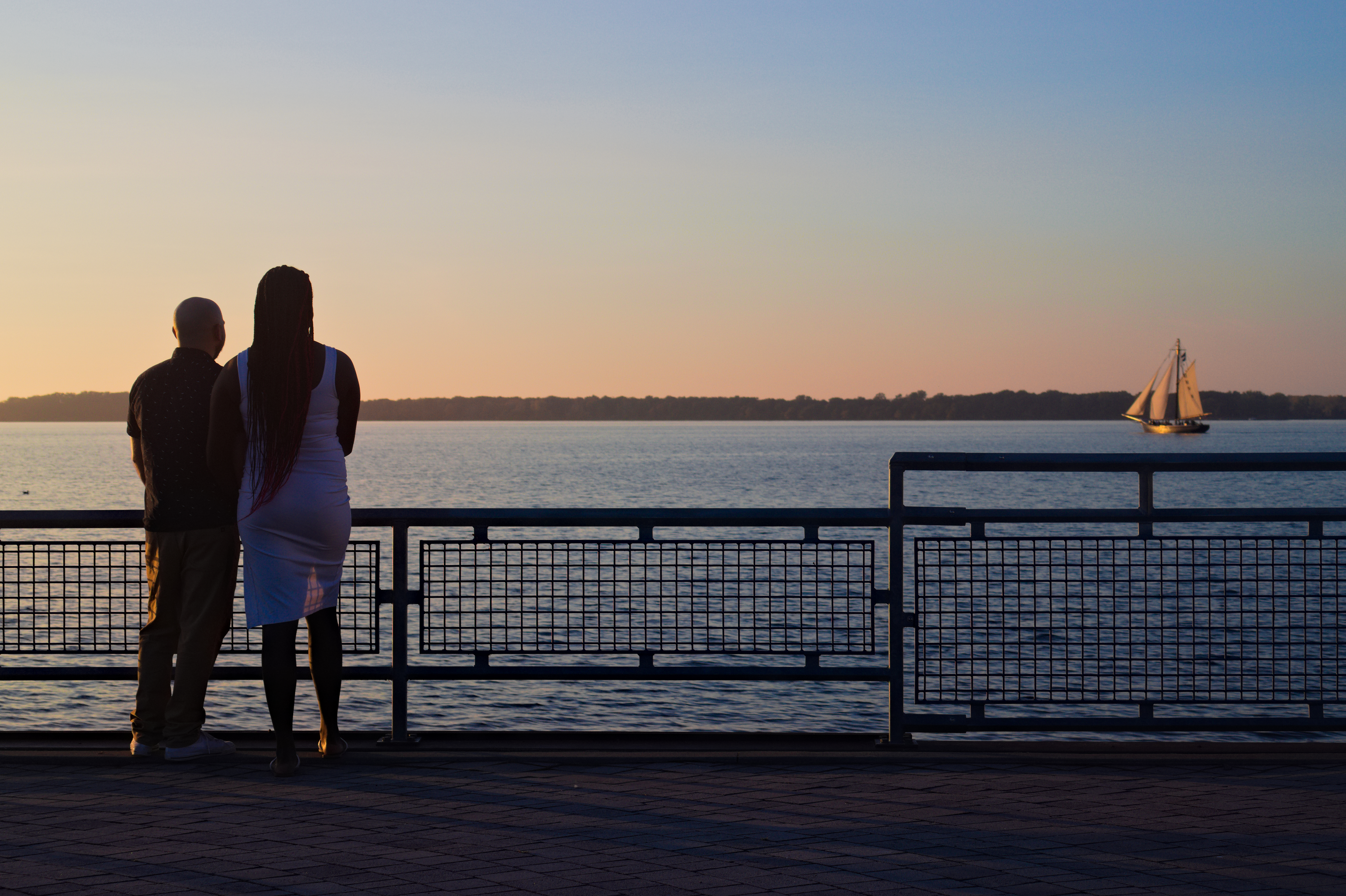 Couple watching sailboat sunset