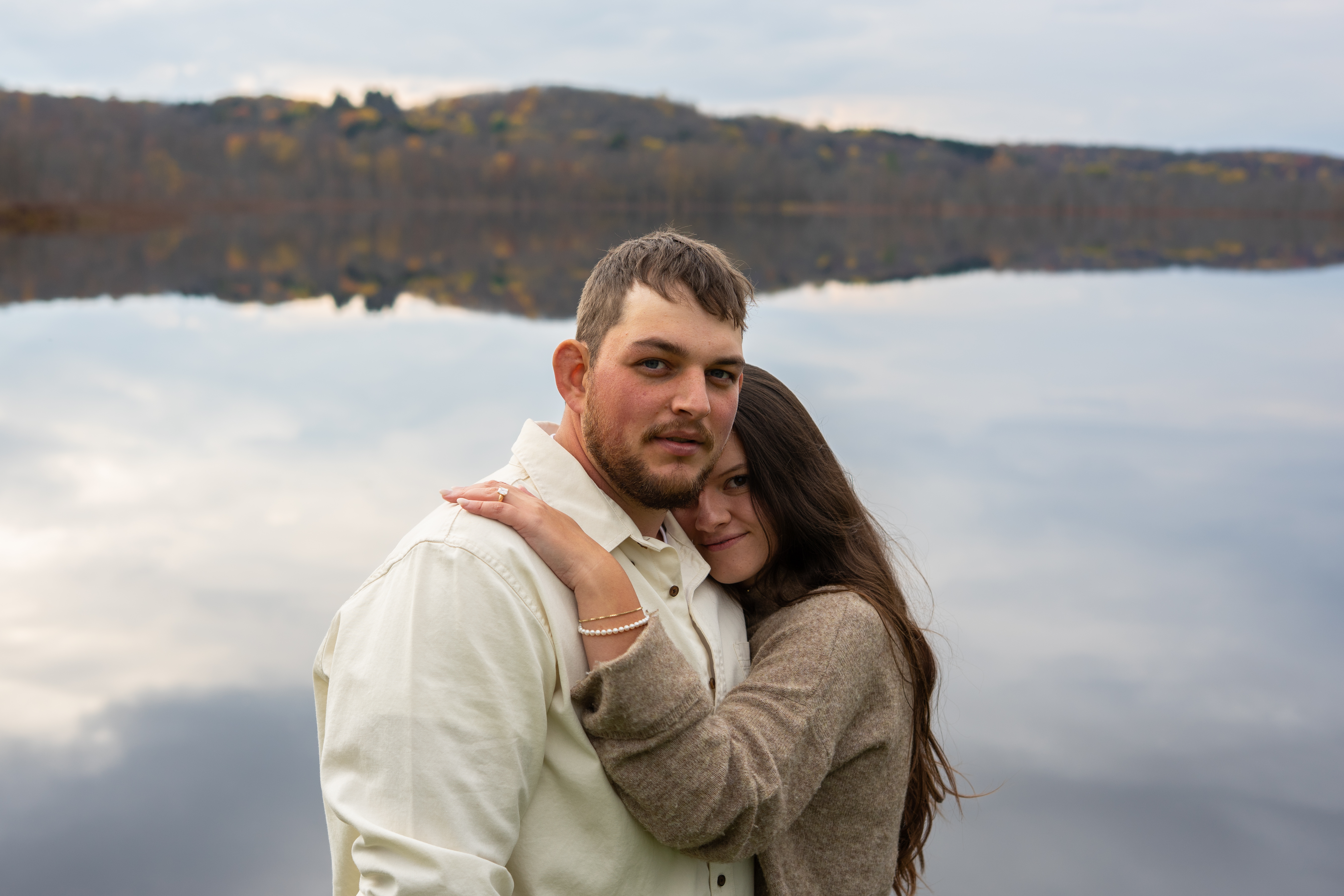 Couple embrace by lake autumn